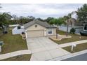 Single-story house with a driveway and landscaped yard at 7943 Merchantville Cir, Zephyrhills, FL 33540