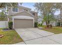 Two-story house with beige exterior, two-car garage, and manicured lawn at 10525 Lucaya Dr, Tampa, FL 33647