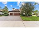 Upgraded house with a three-car garage and paver driveway at 12482 Wild Berry Trl, Odessa, FL 33556