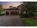 Luxury home with stone exterior, double doors and paver driveway at 12482 Wild Berry Trl, Odessa, FL 33556