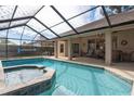 Relaxing screened pool and spa with patio furniture at 16809 Woburn Ln, Lutz, FL 33549