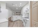 Modern white kitchen with a breakfast bar and stainless steel appliances at 1946 Hammocks Ave # 803, Lutz, FL 33549