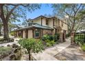 Tan two-story townhome with green metal roof, landscaping, and walkway at 2670 Sequoia Ter # 1406, Palm Harbor, FL 34683