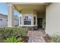 Covered entry with stone accents and a charming sitting area at 2721 Tarragona Way, Wesley Chapel, FL 33543