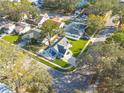 Aerial view showing a house and neighborhood with lush green trees at 3102 Jarvis St, Holiday, FL 34690