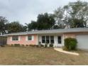 Pink Ranch style home with a grey roof and a two car garage at 3230 San Bernadino St, Clearwater, FL 33759