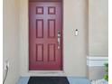 Elegant dark red front door with smart lock and security camera at 3795 Morgons Castle Ct, Land O Lakes, FL 34638