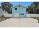 Light blue house with a white fence and driveway at 6416 Finance Ave, Weeki Wachee, FL 34607