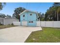 Light blue house with a white fence and driveway at 6416 Finance Ave, Weeki Wachee, FL 34607