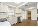 Bright kitchen with white cabinets, stainless steel appliances, and a view to the backyard at 7930 Datura Lane Ln, New Port Richey, FL 34653