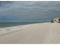 Scenic beach view with cloudy skies and distant buildings at 8581 W Gulf Blvd, Treasure Island, FL 33706