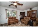 Living room with brown leather furniture and wood-look floors at 8742 Narcissus Ave, Seminole, FL 33777