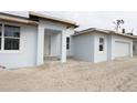 Unfinished home exterior with light paint and white garage at 9032 Evelyn Rd, Englewood, FL 34224