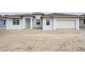 Newly constructed light blue house with white garage doors at 9032 Evelyn Rd, Englewood, FL 34224