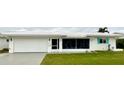 White house with a white garage door, green lawn, and teal shutters at 9920 34Th N Way, Pinellas Park, FL 33782