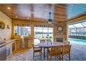 Outdoor kitchen with built-in grill, fireplace, and seating area at 10929 Brooksnest Ct, Lithia, FL 33547