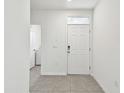 Interior view of a bright and airy entryway with a door leading to the laundry room at 16933 Trite Bend St, Wimauma, FL 33598