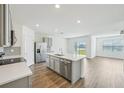 Modern kitchen with gray cabinets, an island, and a view to the backyard at 31814 Oyster Trellis Ln, Wesley Chapel, FL 33545