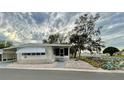 White manufactured home with covered patio and walkway, surrounded by trees at 34212 Canal N Dr # B, Pinellas Park, FL 33781
