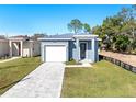 New construction home features a gray exterior, white garage door, and a stone driveway at 3515 55Th Ave N, St Petersburg, FL 33714