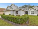 Gray house with two-car garage and lush green hedges at 3624 Muirfield Ct, New Port Richey, FL 34655