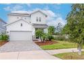 Two-story house with white siding, paver driveway, and palm trees at 3715 Front Park Dr, Wesley Chapel, FL 33543