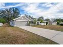 Gray house with a two-car garage and a long driveway at 6069 Newmark St, Spring Hill, FL 34606