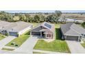 One-story house with gray siding and solar panels, aerial view at 38189 Countryside Pl, Dade City, FL 33525