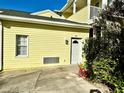 Exterior view of yellow building, showing a side entrance and landscaping at 458 Grant St, Dunedin, FL 34698