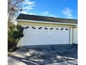 Attached one-car garage with white door and window inserts at 458 Grant St, Dunedin, FL 34698