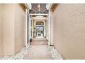 Covered walkway leading to double doors and a view into the living area at 5040 Ruby Flats Dr, Wimauma, FL 33598