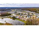 Property's aerial view shows location near a lake in a residential community at 6621 Gentle Ben Cir, Wesley Chapel, FL 33544