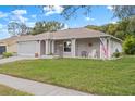Brick ranch home with a screened-in garage and American flag at 8130 Merrimac Dr, Port Richey, FL 34668