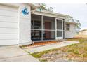 Inviting front entrance with a screened porch and walkway at 9825 Lakeside Ln, Port Richey, FL 34668