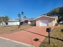 Newly paved driveway and updated landscaping in front of a single story home at 10202 Oak Hill Dr, Port Richey, FL 34668