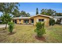 Tan single-story house with landscaping and driveway at 1034 Sunnydale Dr, Clearwater, FL 33755