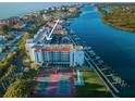 Aerial view of condo building near waterway, tennis courts at 19111 Vista Bay Dr # 304, Indian Shores, FL 33785