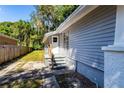 Side view of gray house with wooden steps and backyard at 2002 E Ellicott St, Tampa, FL 33610