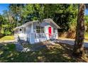 Gray house with red door and a spacious yard at 2002 E Ellicott St, Tampa, FL 33610