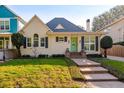 Cute yellow house with green door and well-kept lawn at 2812 W Neptune St, Tampa, FL 33629