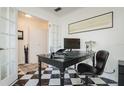 Bright home office with a black desk, two laptops, and a checkerboard floor at 2812 W Neptune St, Tampa, FL 33629