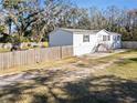 Side view of a white manufactured home with wooden fence at 3752 Elfers Pkwy, New Port Richey, FL 34655