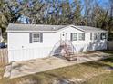 Front view of a white manufactured home with a metal staircase at 3752 Elfers Pkwy, New Port Richey, FL 34655