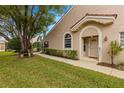 House exterior showcasing a walkway, landscaping, and a light-beige color scheme at 3838 Muirfield Ct, Palm Harbor, FL 34685