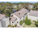 Lovely aerial view of a waterfront townhouse with mature trees and landscaping, offering a serene setting and charming curb appeal at 4154 Pinelake Ln # 101, Tampa, FL 33618