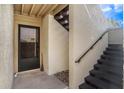 Inviting front entrance with a dark door, adjacent staircase, and stucco walls offering a unique architectural detail at 4154 Pinelake Ln # 101, Tampa, FL 33618