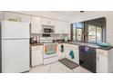 Bright kitchen with white cabinets, modern appliances, and water view at 4154 Pinelake Ln # 101, Tampa, FL 33618