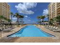 Expansive resort-style pool with plenty of lounge chairs and palm trees at 470 Mandalay Ave # 306, Clearwater Beach, FL 33767