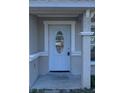 Light blue front door with glass accents and a covered porch at 5352 Tangerine Dr, New Port Richey, FL 34652