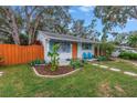 Cute cottage with a fenced yard, stone path, and blue chairs on porch at 5402 8Th S Ave, Gulfport, FL 33707